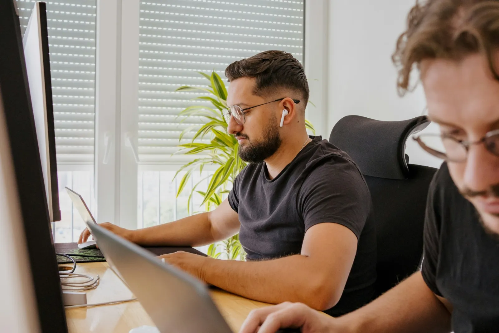 Zwei Entwickler arbeiten nebeneinander an ihren Bildschirmen